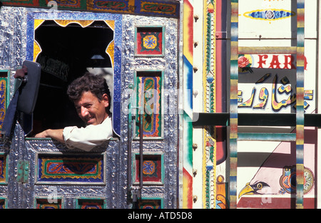 Seated in his decorated cab a friendly Pakistani truck driver on the Karakoram Highway to China Pakistan Stock Photo