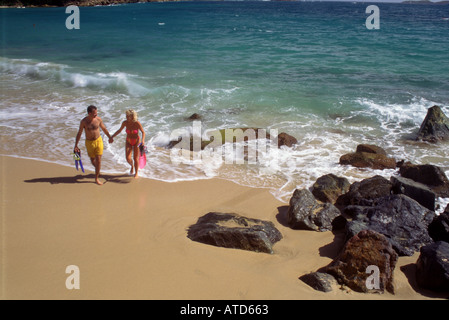 Couple walks on beach after snorkeling in the clear blue Caribbean waters of St Thomas on the US Virgin Islands Stock Photo