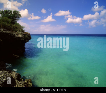 Turquoise sea meets blue sky near Kipps Beach off the rocky coast of the Caribbean island of Curacao Stock Photo