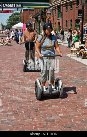 People using rented Segway Personal Transporters historical Distillery District Toronto Canada Stock Photo