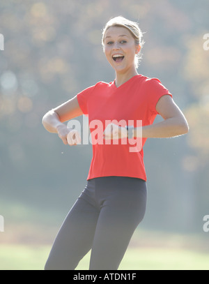 young woman leaping up enjoying exercising in the park Stock Photo