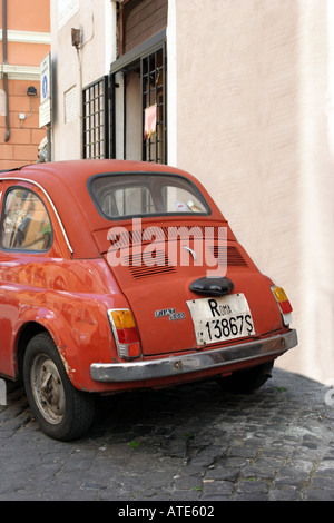 An iconic old red Fiat 500 parked in a cobbled street in Rome, Italy ...