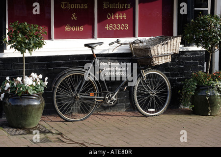 Butchers delivery bicycle outside shop Stock Photo