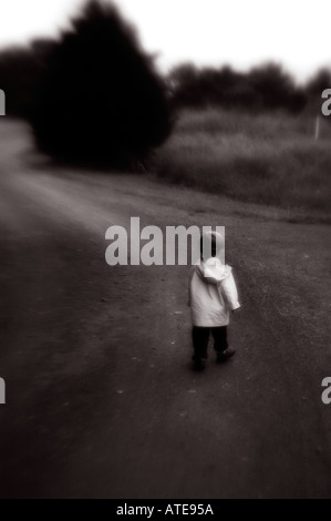 dream like Small child walking on pathway leading away Stock Photo
