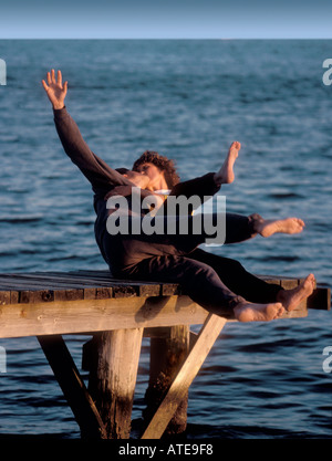 A couple kissing passionately on a dock falls backward Stock Photo