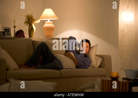 Young man lying on a couch Stock Photo