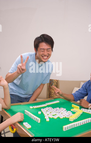 Three people sitting around a mahjong table Stock Photo