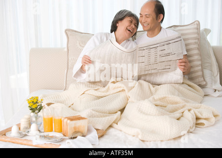 Mature couple sitting on the bed looking at each other Stock Photo