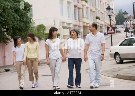 Parents walking with their three daughters Stock Photo