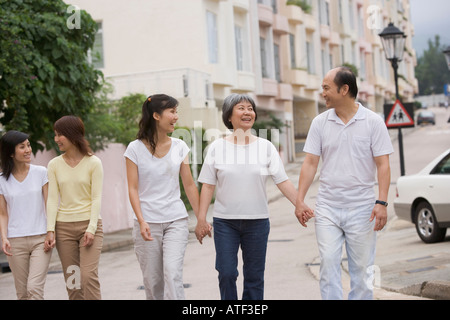 Parents walking with their three daughters Stock Photo