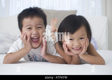 Portrait of a brother lying on the bed with his sister Stock Photo