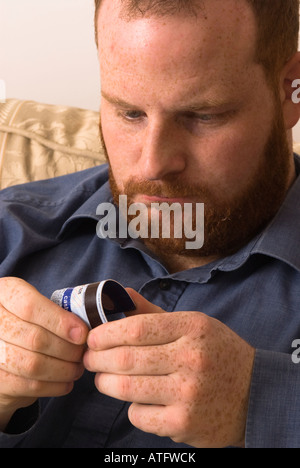 angry young man destroying credit debit bank card to avoid debt and better manage finances Stock Photo