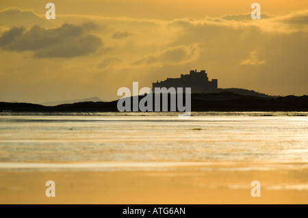 Bamburgh Castle, on the coast of Northumberland, England, viewed from the north across mudflats at low tide from Lindisfarne. Stock Photo