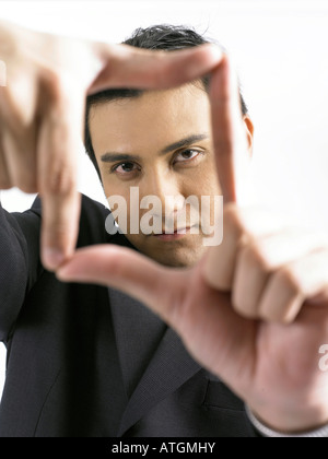 Young businessman looking through finger frame Stock Photo