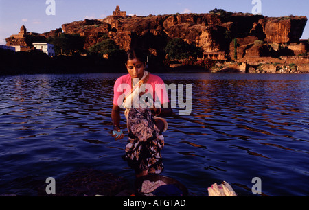 A woman washes clothes at the shore of Agastya (Tirtha) lake in Badami located in the Bagalkot district of Karnataka, India Stock Photo