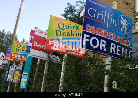 Multiple estate agents boards To Let and For Sale Signs outside Private Flats houses Stock Photo