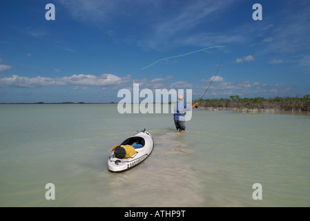A fly fisherman casts to stealthy bonefish while salt water flats fishing in Boca Paila Mexico. Stock Photo