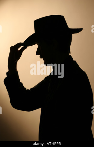 Silhouette of a cowboy tipping his hat Stock Photo