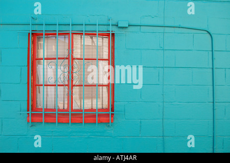 Blue/green wall with a red framed window. Stock Photo
