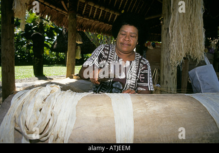 This Fijian woman dressed traditional clothing is making paper from local wood in a small museum on Viti Levu near Nadi Stock Photo