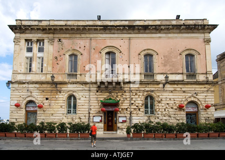 A Chinese restaurant in an old building pockmarked with bullet holes on the Piazza C.Battisti in Syracuse, Sicily Stock Photo