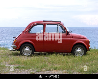 Classic Red Fiat 500 motor car with picnic basket parked on