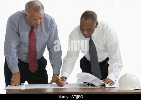 Two engineers looking at a blueprint Stock Photo