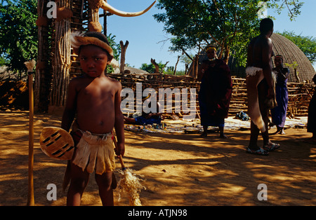 Young Zulu dancer and adults in tourist village, Uganda Stock Photo