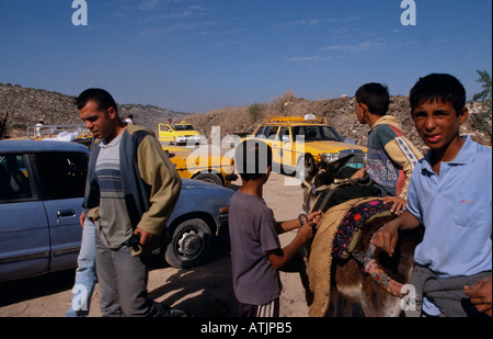 Boys and their donkey on a destroyed road Stock Photo