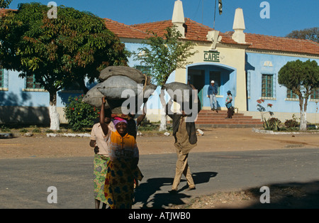 Locals carrying sacks of food on head leaving CARE Headquarters. Suarimo, Angola. Stock Photo