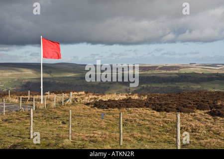 Red flag flying on the edge of Army training land in Swaledale, Yorkshire. Stock Photo