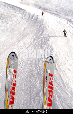 View of ski tips and skiers from a chair lift on the slopes of Schmittenhohe mountain above Zell am See  Stock Photo