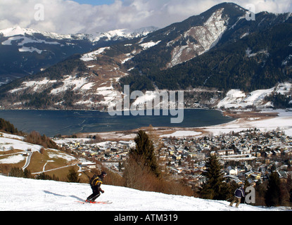 Snowboarder skier on the slopes of the Schmittenhohe mountain overlooking Schuttdorf and Lake Zell am See  Stock Photo