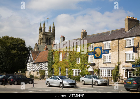 The Black Swan Hotel old coaching inn in Market Square with All Saints Church tower beyond. Helmsley North Yorkshire England UK Stock Photo