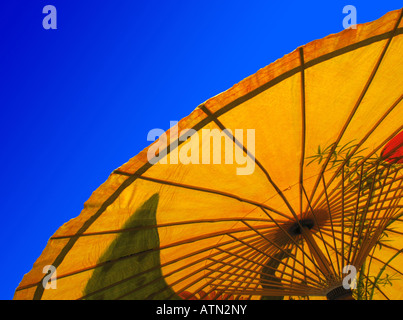 Yellow Asian or Oriental parasol, seen from below, against a clear deep blue sky Stock Photo