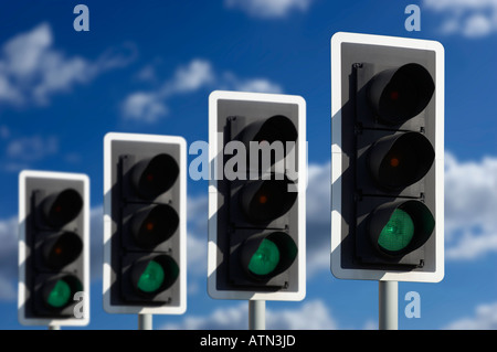 ROW OF FOUR ROAD TRAFFIC LIGHTS SHOWING GREEN Stock Photo