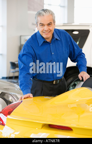 Hispanic car salesman looking at new car Stock Photo