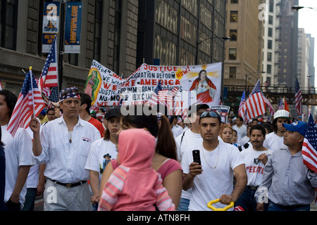 Chicago Illinois immigration rally worker carrying an American flag other men and women carrying banner Stock Photo