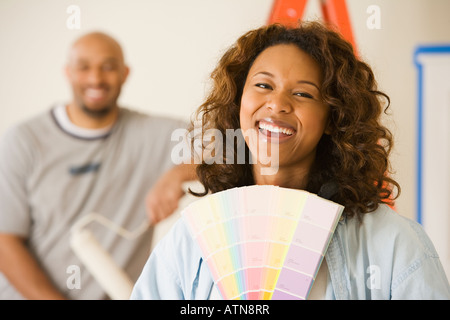 African woman holding paint swatches Stock Photo