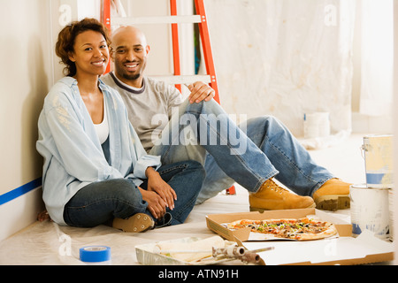African couple taking lunch break from painting Stock Photo