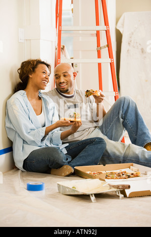 African couple taking lunch break from painting Stock Photo