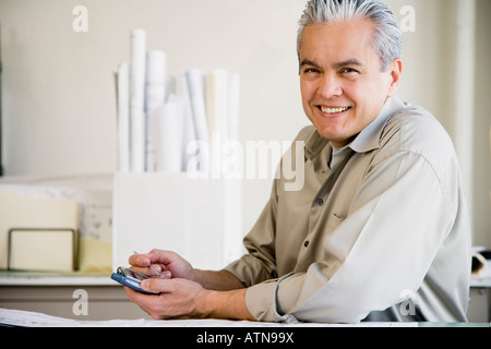 Hispanic male architect using electronic organizer Stock Photo