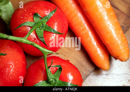 A close-up of bunch of vegetables carrots and cluster tomatoes Stock Photo