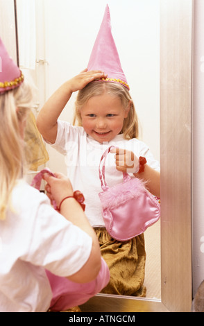 Little girl is dressing like a princess in front of the mirror Stock Photo