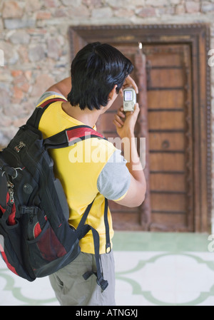 Rear view of a young man taking a photograph Stock Photo