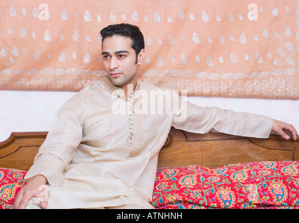 Young man sitting on the bed Stock Photo