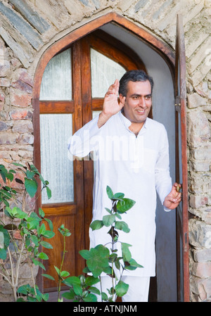 Mid adult man waving his hand Stock Photo