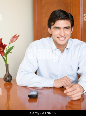 Young man sitting at a table and smiling Stock Photo