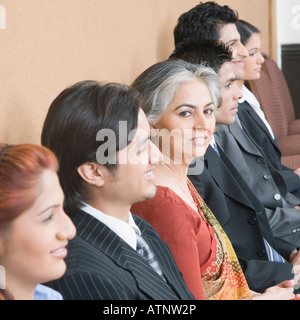 Portrait of a businesswoman sitting with five business executives and smiling Stock Photo