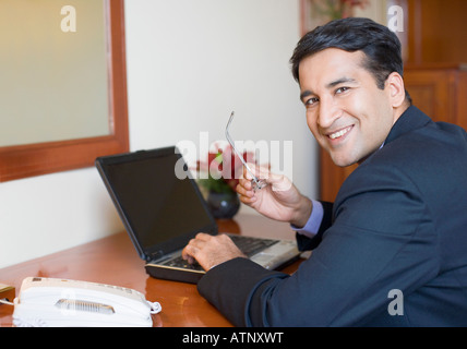 Portrait of a businessman using a laptop and smiling Stock Photo
